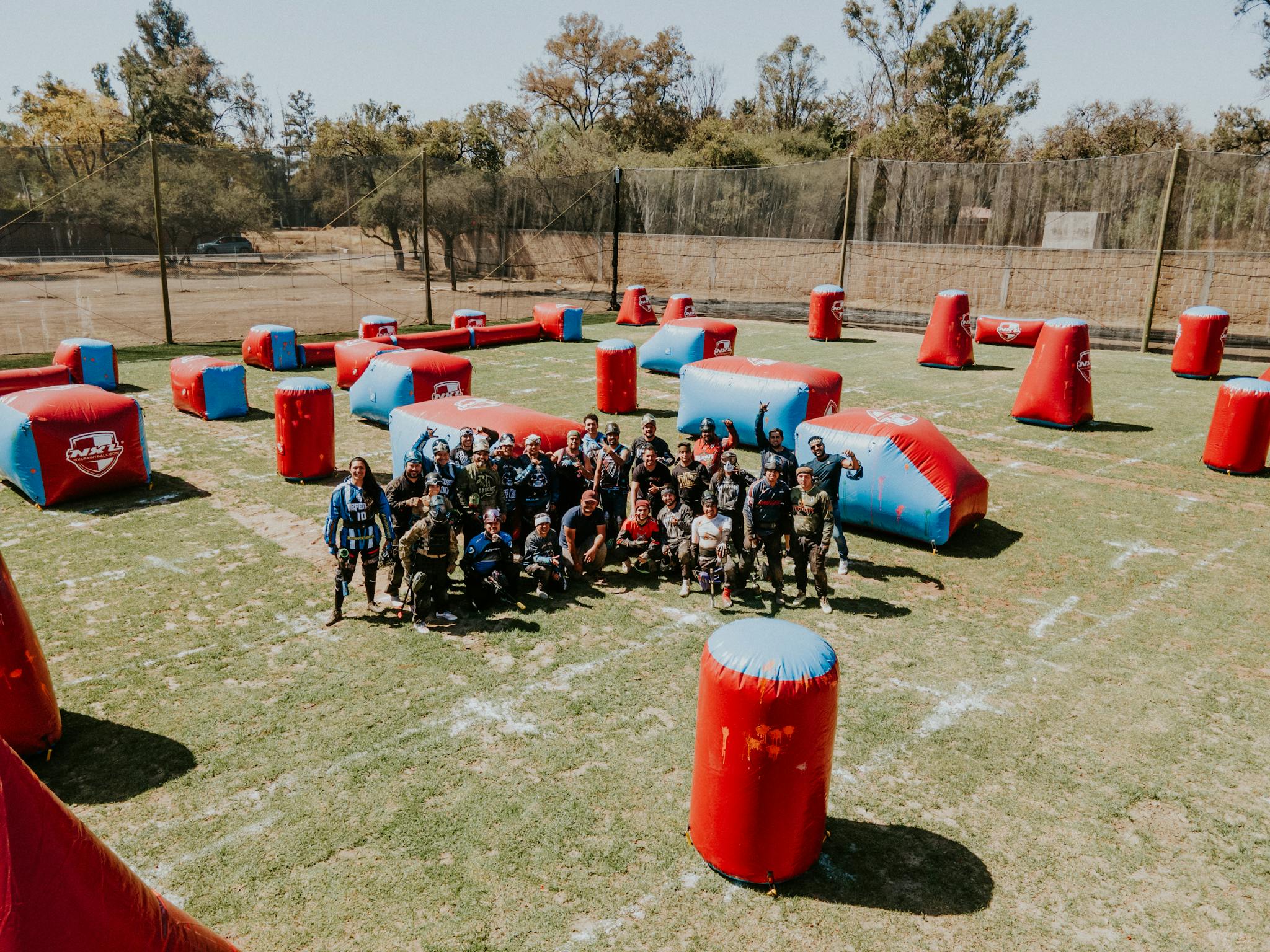 Vista aérea de un grupo grande disfrutando de una partida de laser tag con hinchables en un día soleado
