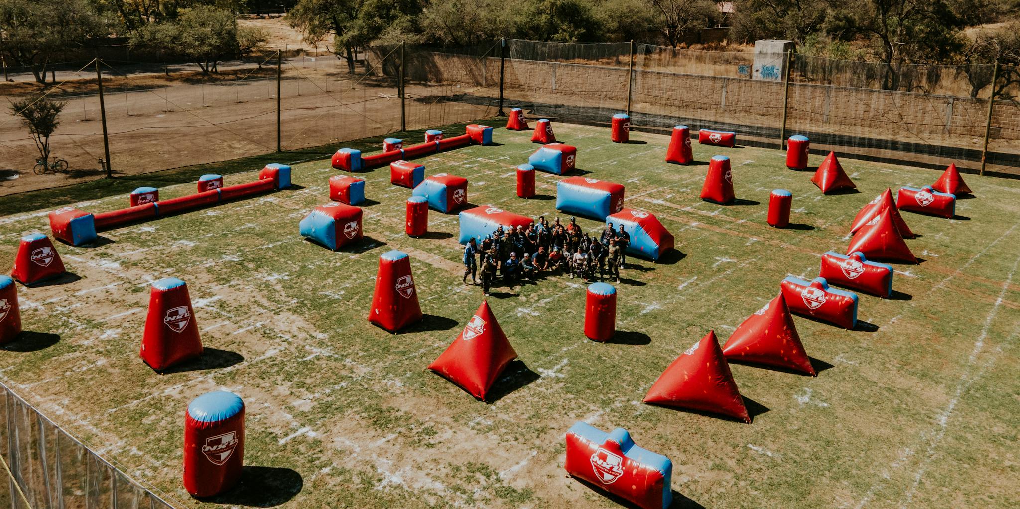 Aerial view of a paintball field with obstacles and players in León, Mexico.