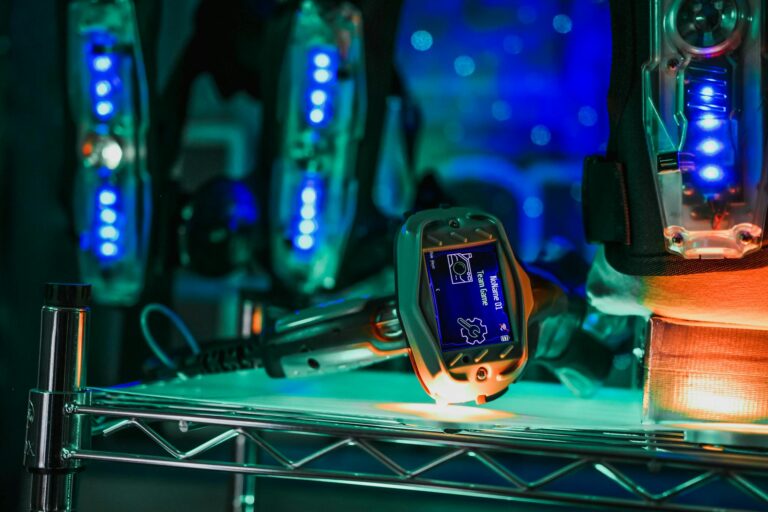 Close-up view of advanced laser tag gear with illuminated details in indoor setting.