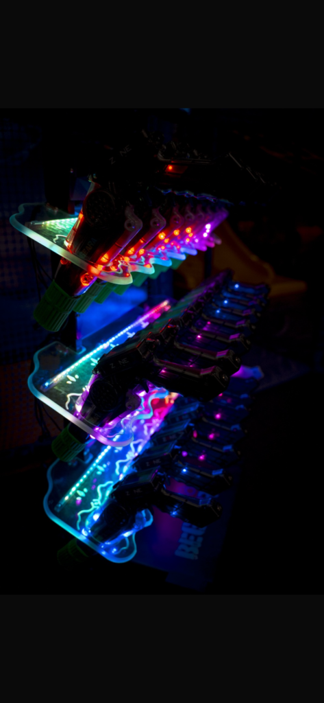 Armas láser con luces LED de colores en su soporte iluminado